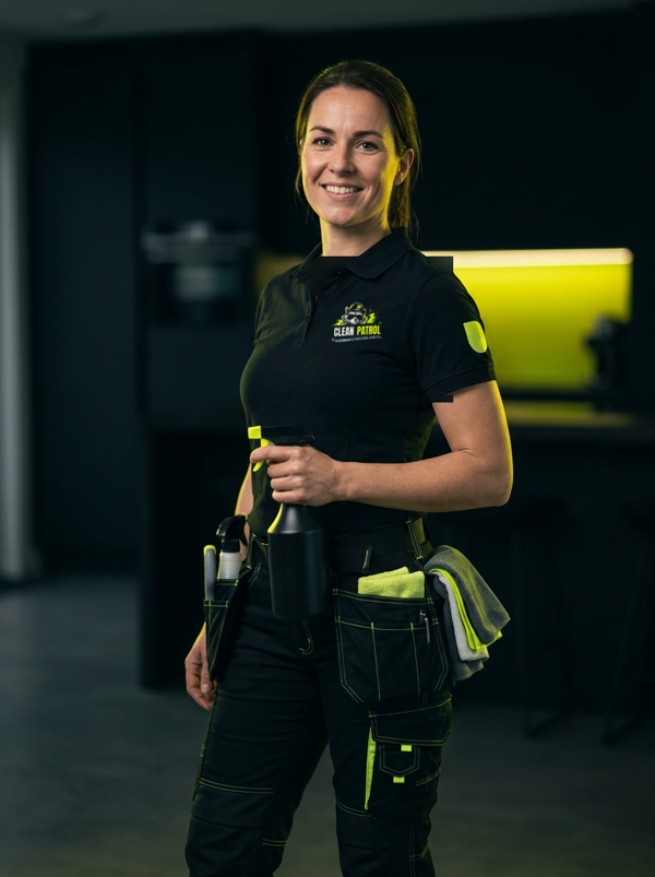 Medewerker van Clean Patrol in zwarte werkkleding met limoengroene details